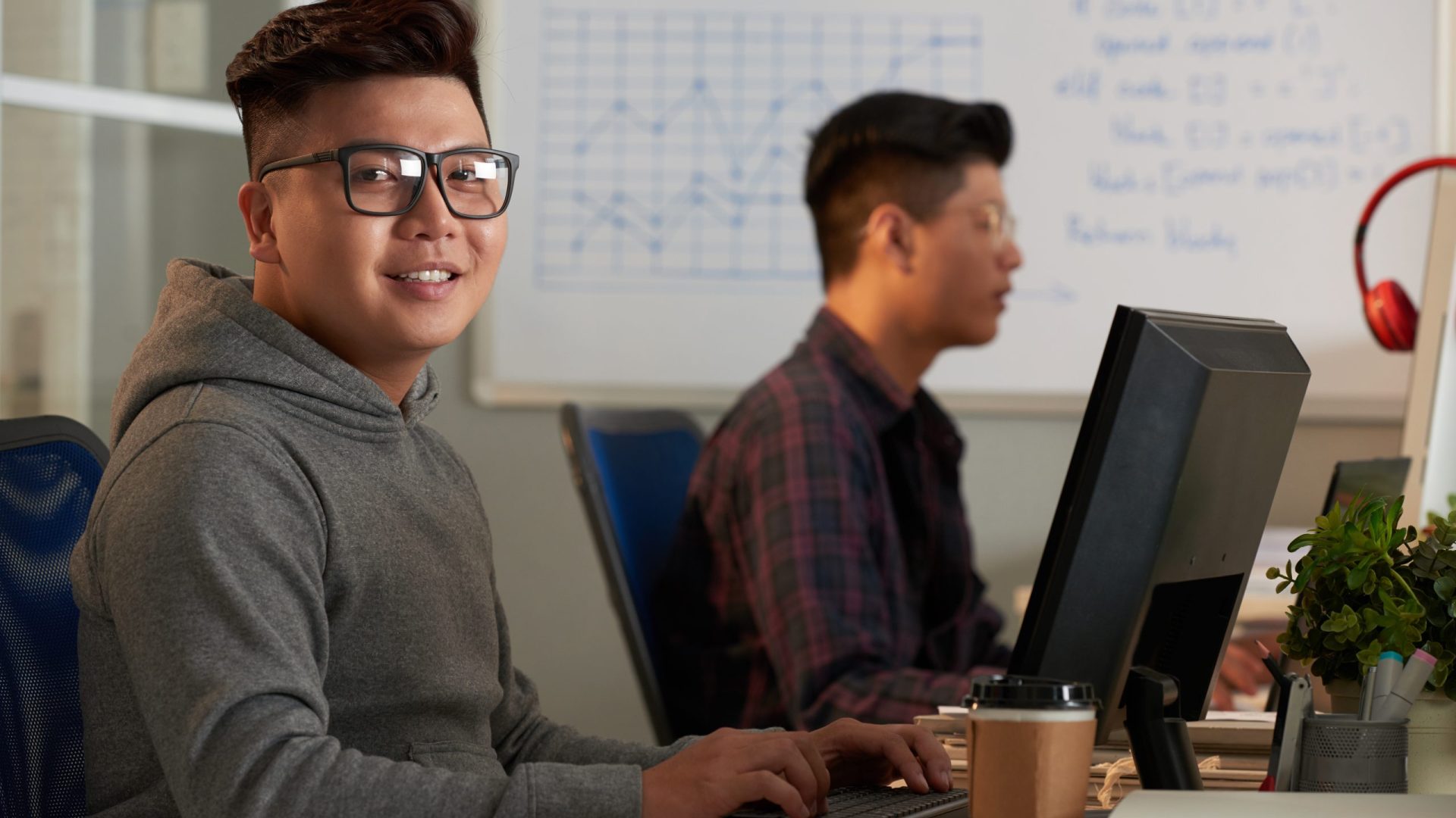 Smiling,Asian,Student,Wearing,Eyeglasses,Looking,At,Camera,While,Sitting